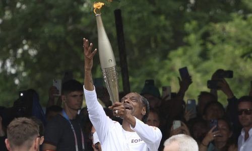 Snoop Dogg carries the Olympic torch before opening ceremony in Paris