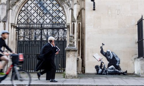 Banksy unveils a new mural of a judge beating a protester outside London court