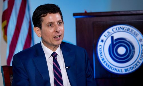 He’s the budget scorekeeper for Congress. Lately, it’s been a tough job