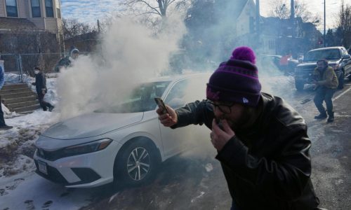 Crowd yells ‘cowards!’ after federal agents crash into a car and fire tear gas in Minneapolis